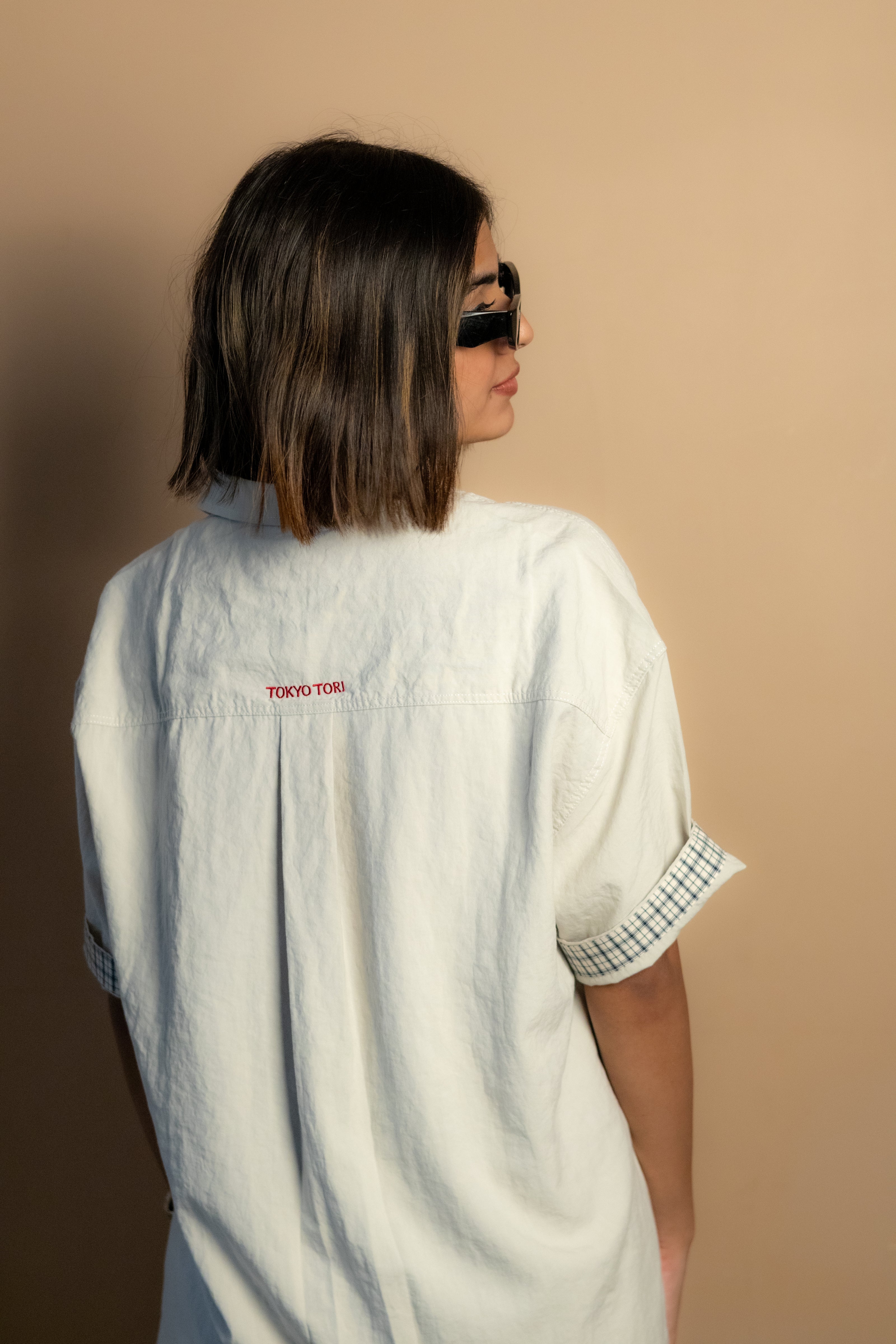stone-colored Camp Shirt, a beige short-sleeve button-up featuring classic plaid trim