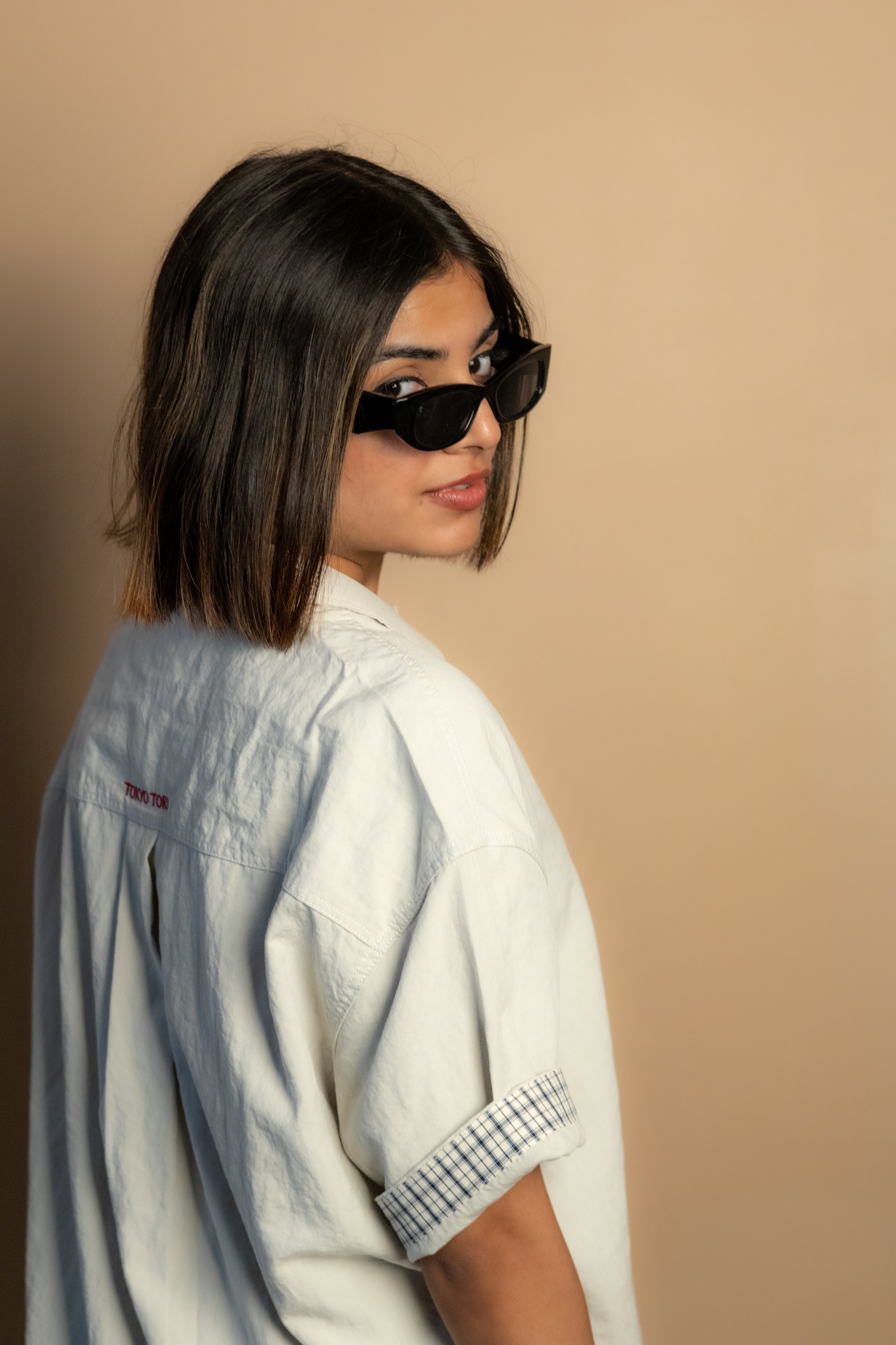 stone-colored Camp Shirt, a beige short-sleeve button-up featuring classic plaid trim